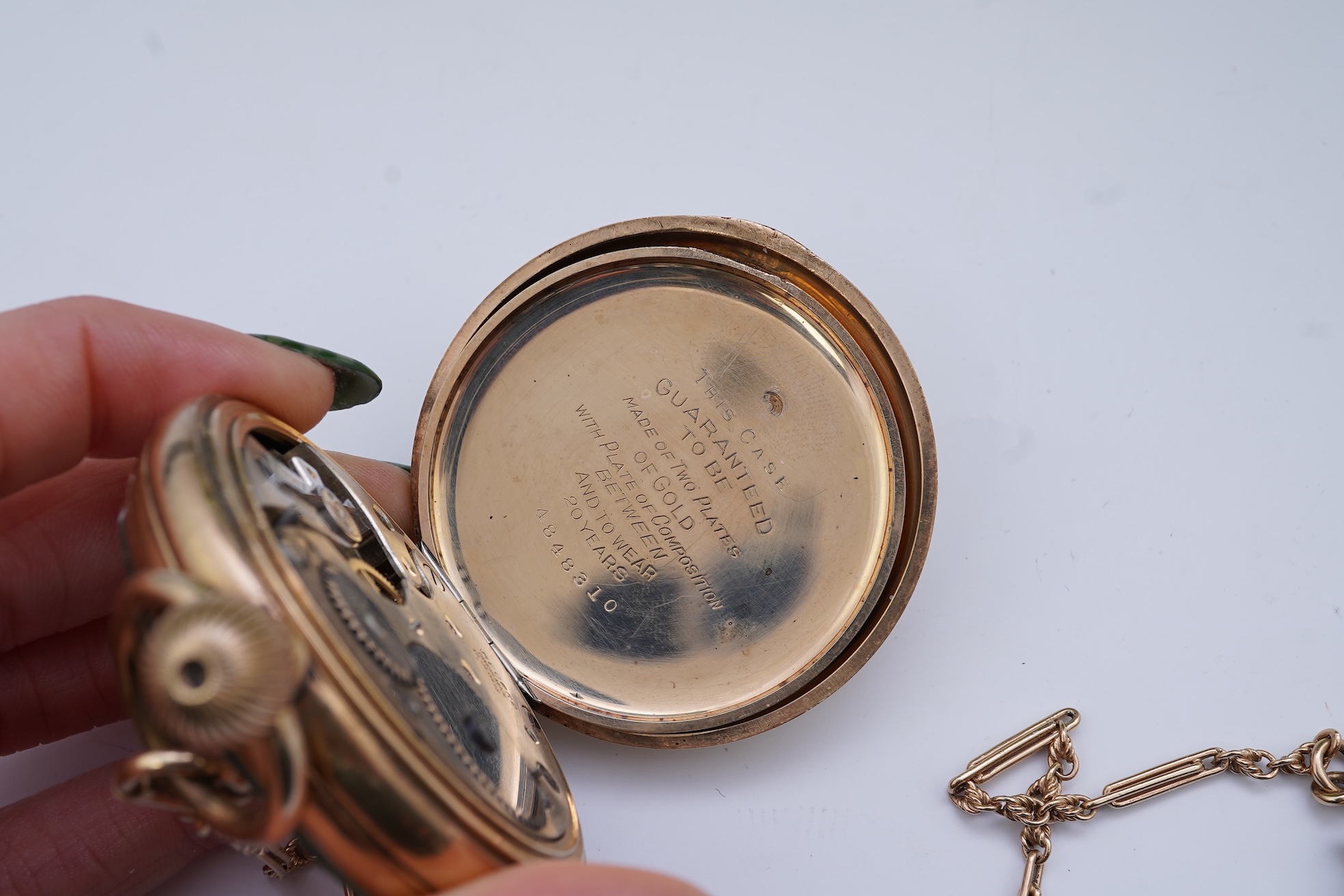 An amethyst fob seal, a gold Albert chain, and a pocket watch